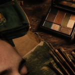 Maquillage harry potter : pinceaux baguettes, palette d’ombres et rouge à lèvres sur table bois